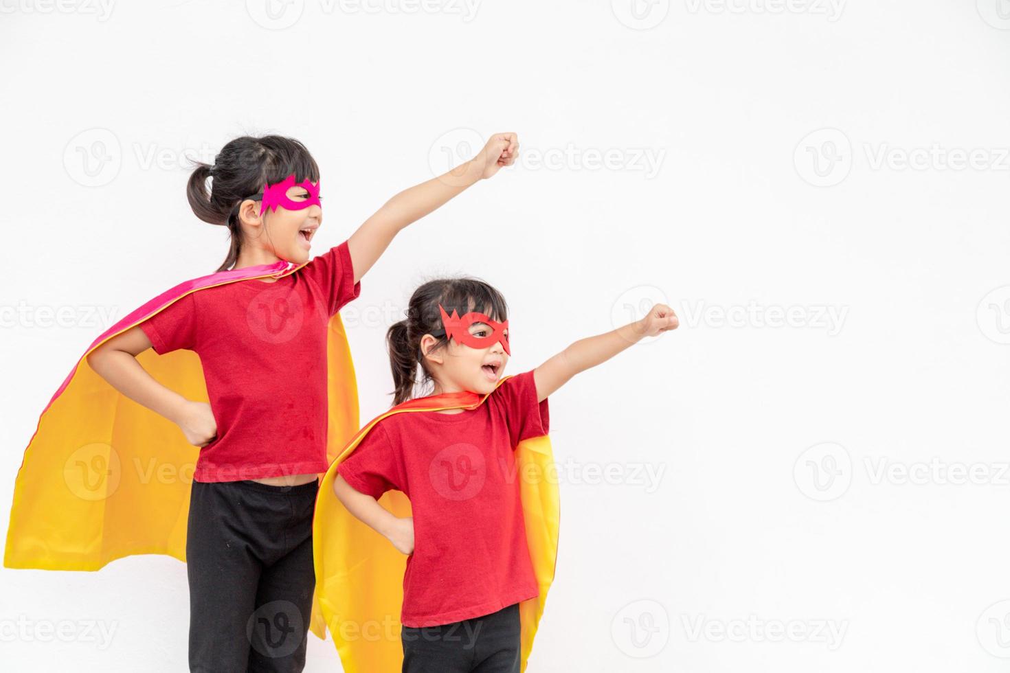 twee meisjes in een superheld kostuum Aan wit achtergrond foto