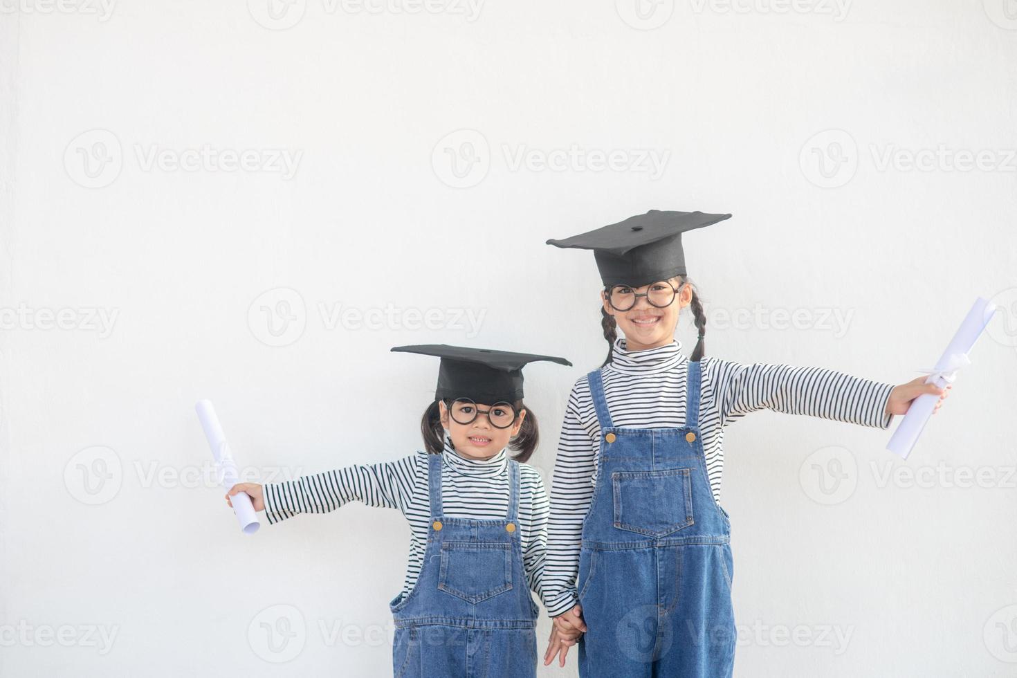 broers en zussen kinderen meisje diploma uitreiking met pet en diploma over- wit. foto