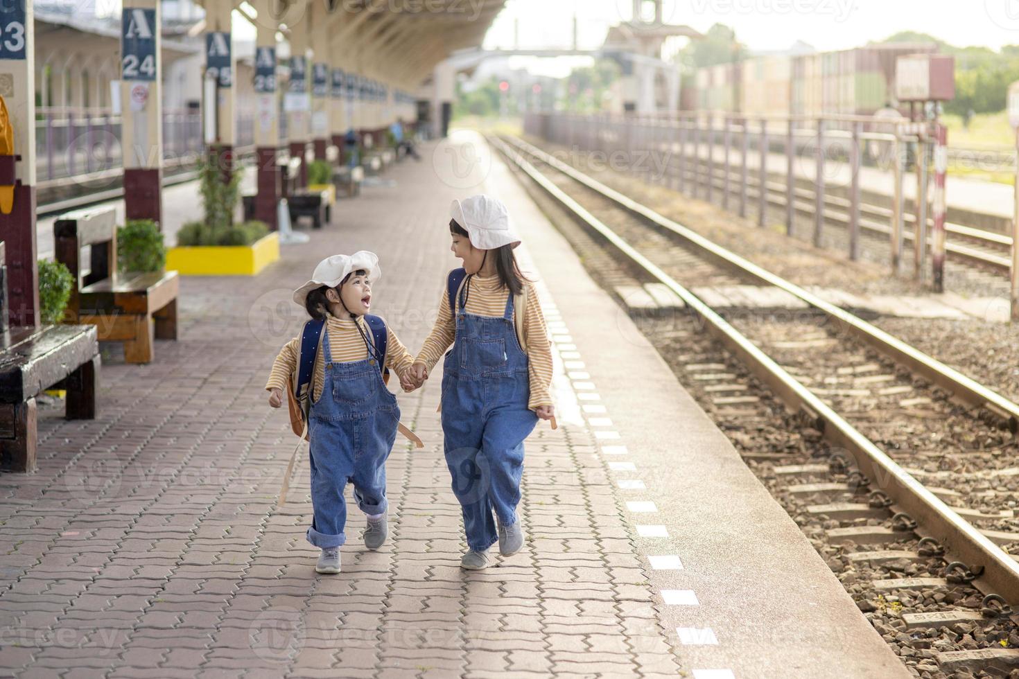 twee meisjes Aan een spoorweg station, aan het wachten voor de trein foto