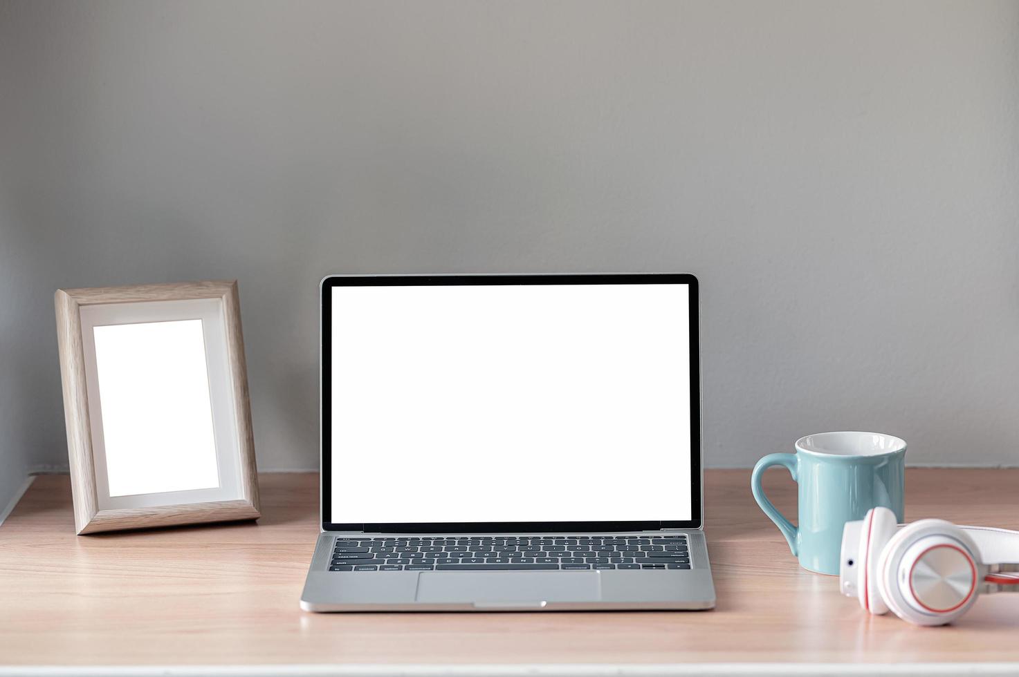 laptop en fotolijstmodel op een tafel foto