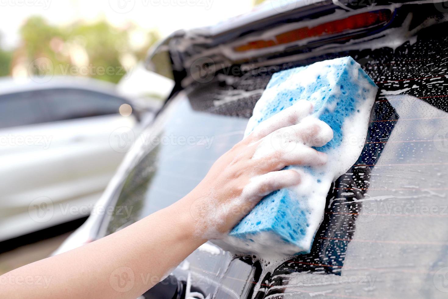 deze Mens is het wassen de auto en schoonmaak de auto. foto