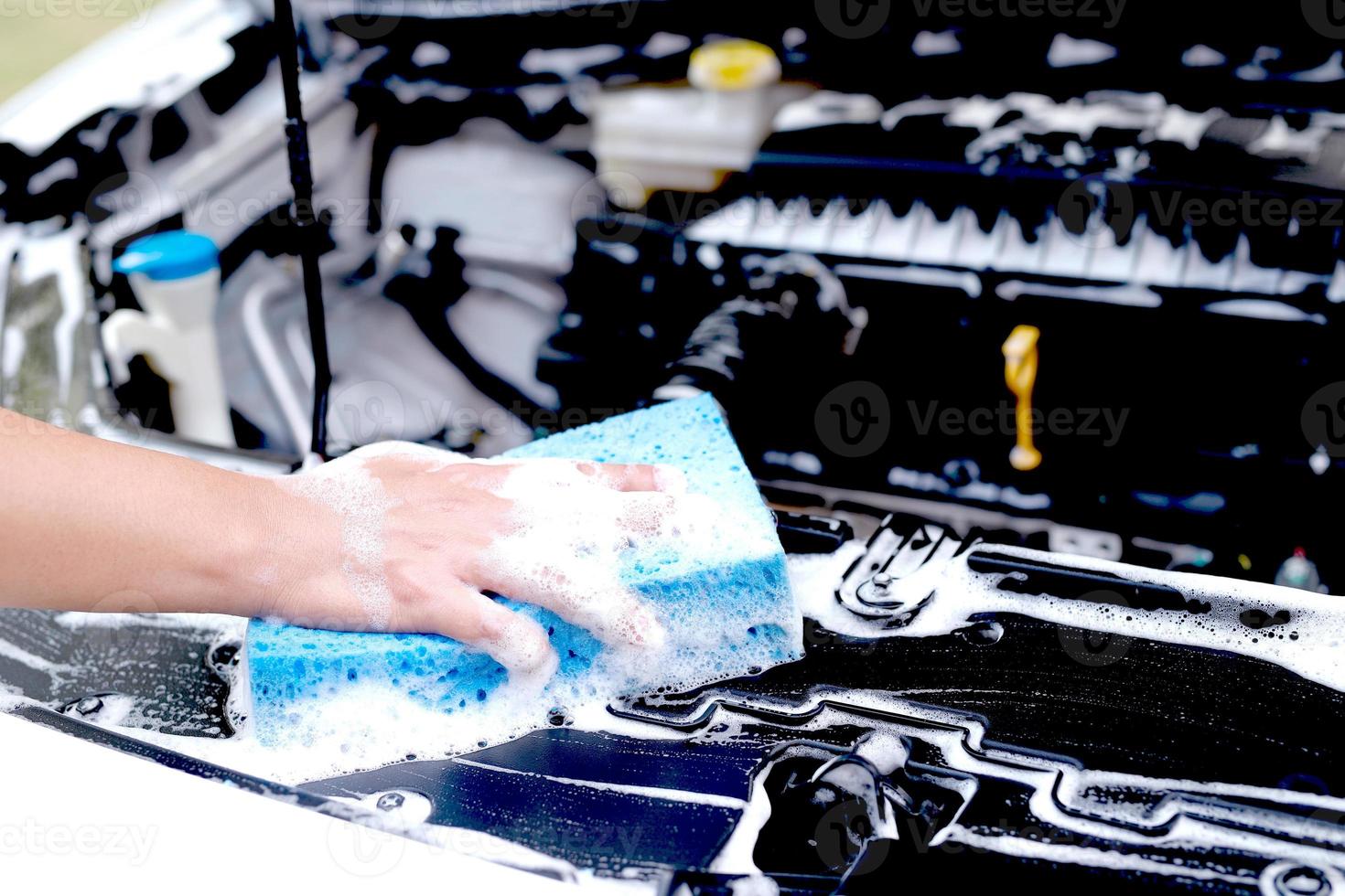 deze Mens is het wassen de auto en schoonmaak de auto. foto