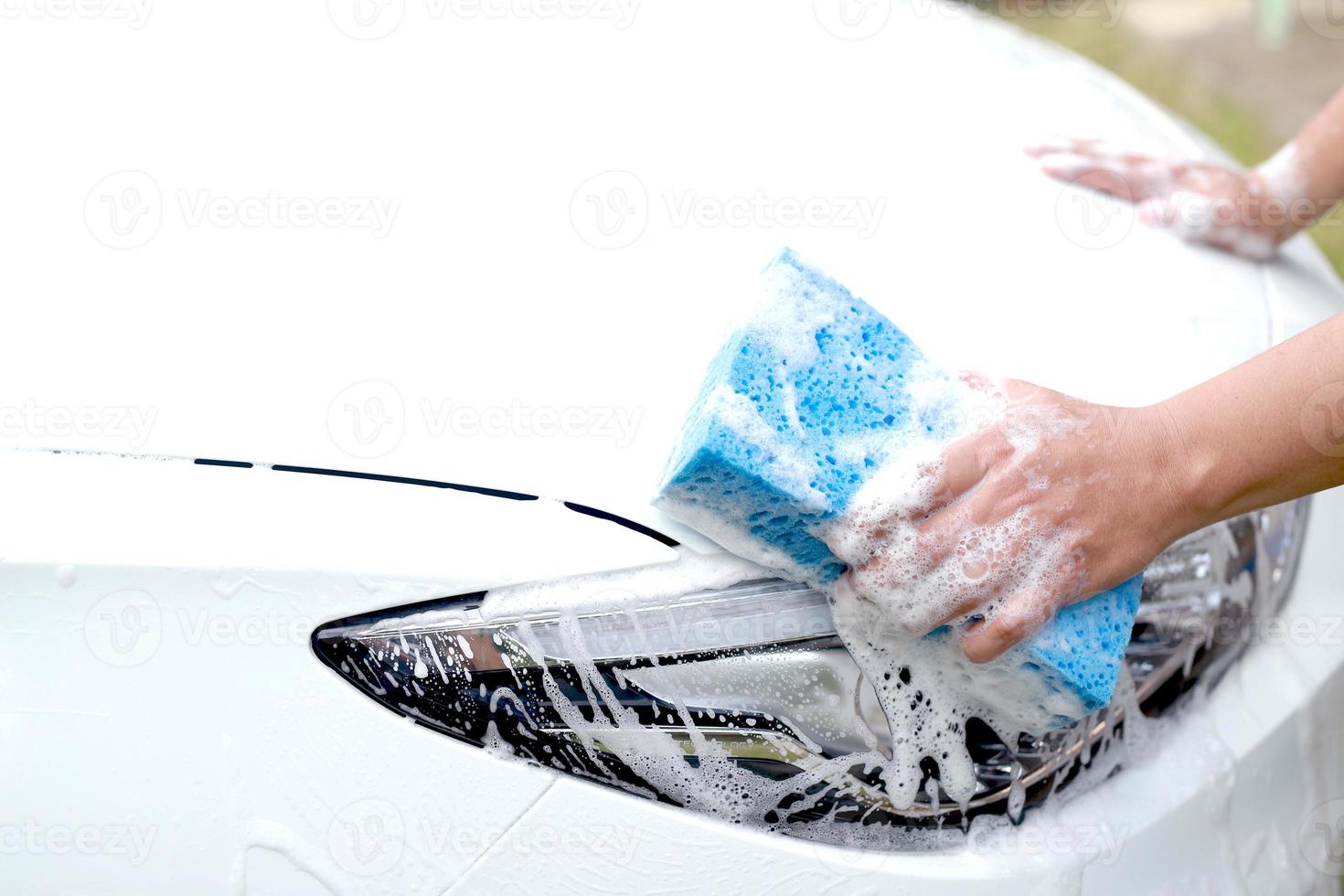 deze Mens is het wassen de auto en schoonmaak de auto. foto