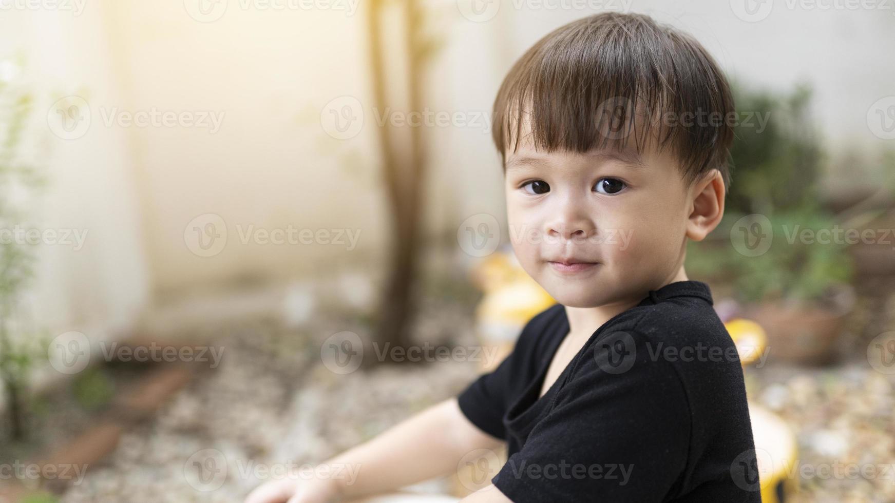 detailopname schattig weinig Aziatisch jongen glimlachen gelukkig buitenshuis. baby gezicht, gelukkig kinderen spelen in de ochtend. zelfverzekerd uitdrukking. de kind gezicht shows vertrouwen. foto