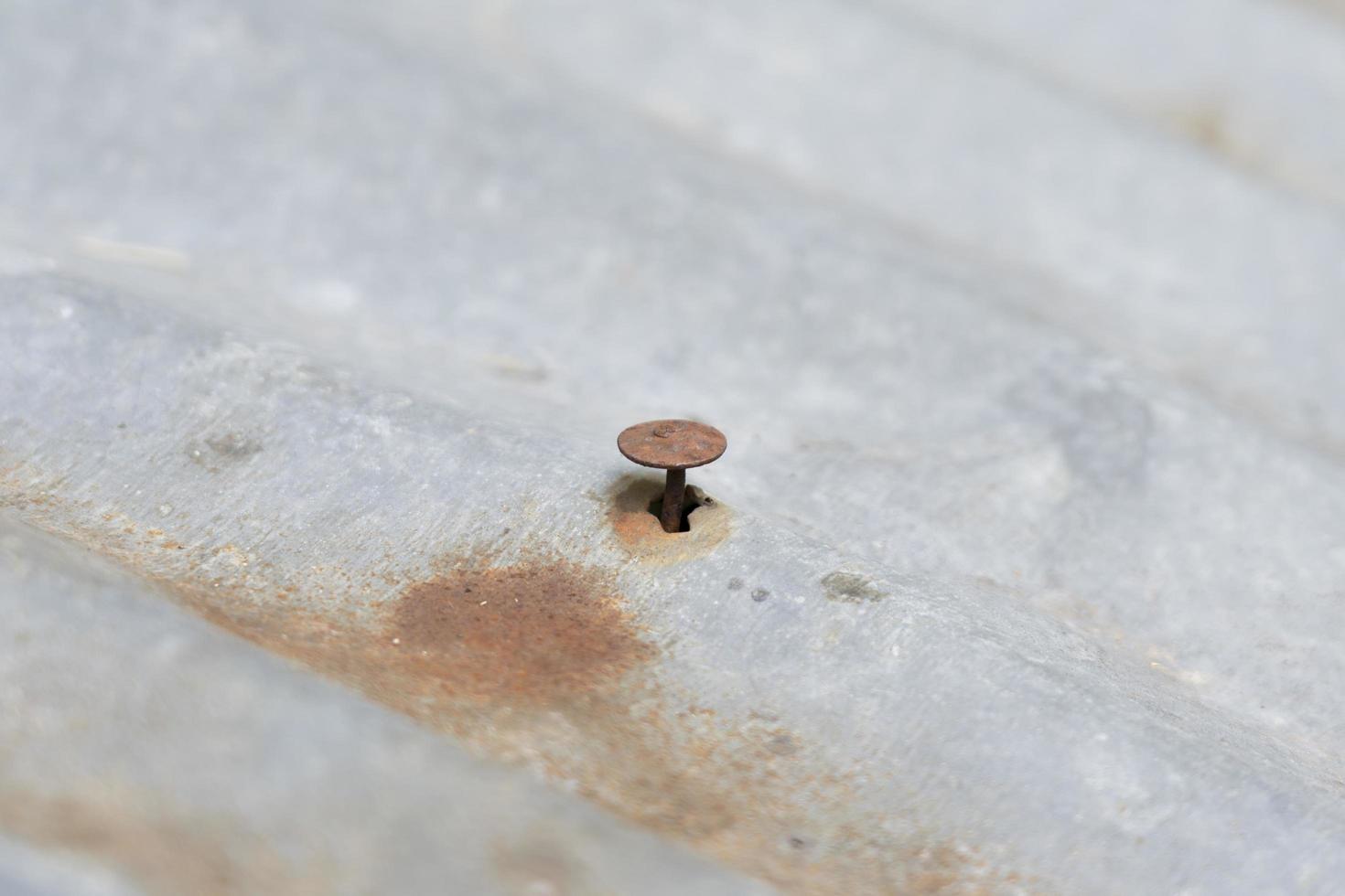 roestig ijzer gaten en nagels Aan een oud gebogen metaal dak. roestig ijzer nagels foto