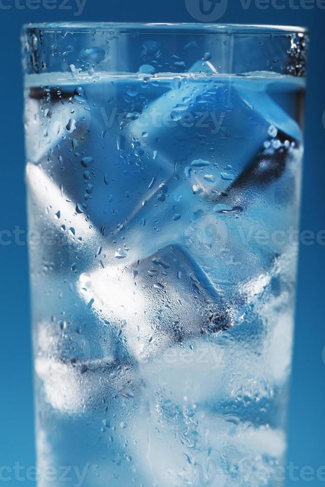 ijs kubussen in een beneveld glas met druppels van ijs water detailopname macro. foto