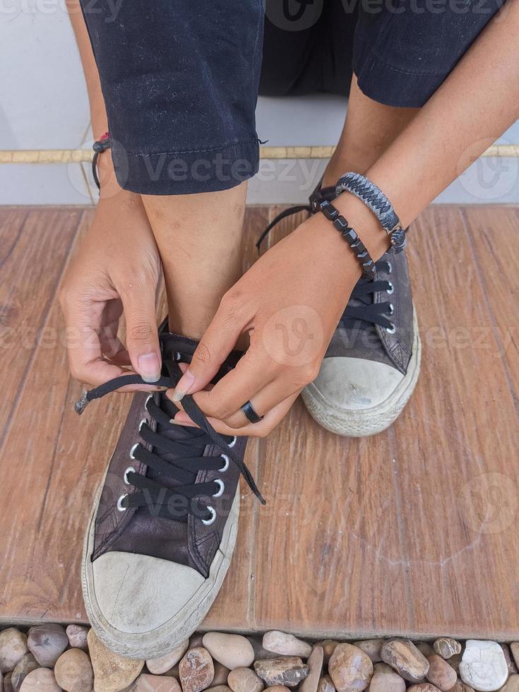 voet portret van een jong vrouw vervelend en koppelverkoop schoenveters Aan de veranda van de huis foto