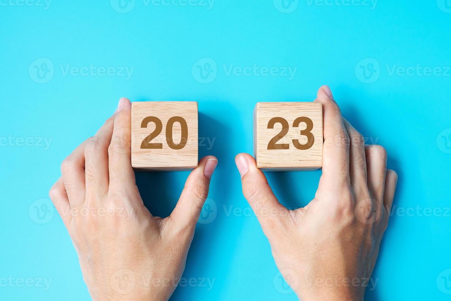 hand- Holding houten kubus blok met 2023 tekst Aan blauw achtergrond. oplossing, plan, opnieuw bekijken, doel, begin en nieuw jaar vakantie concepten foto