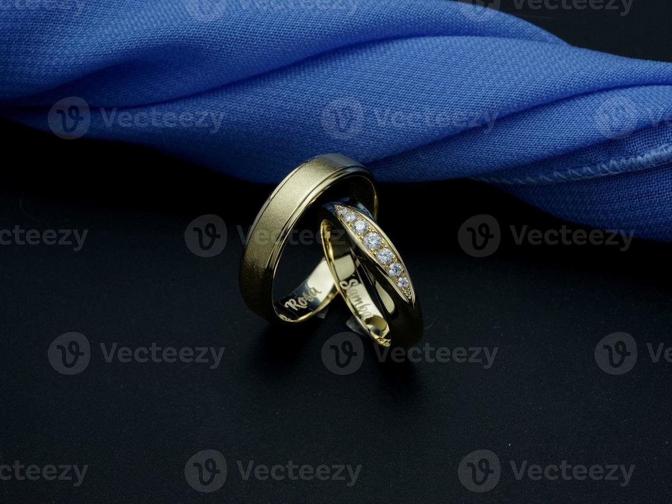 wit goud en geel goud bruiloft ring. paar ring met glanzend en doff afwerking met blauw en zwart achtergrond foto