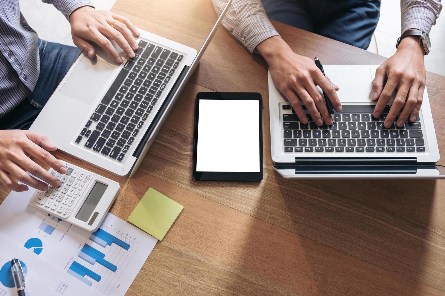 twee professionals die op laptops werken foto