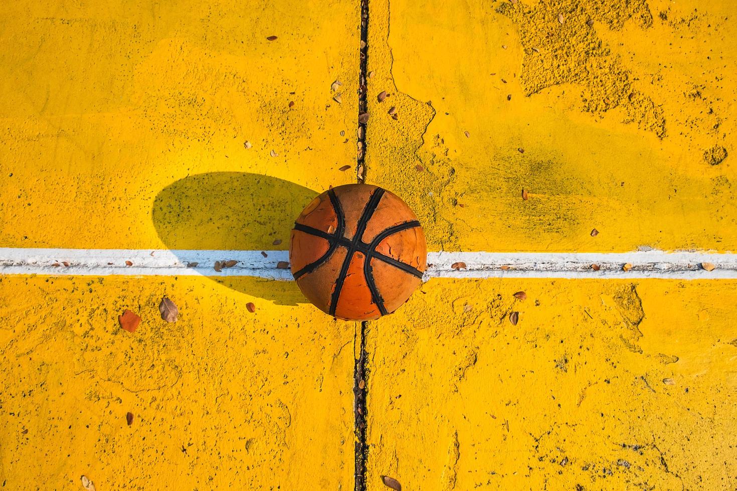 oud basketbal op een geel hof foto
