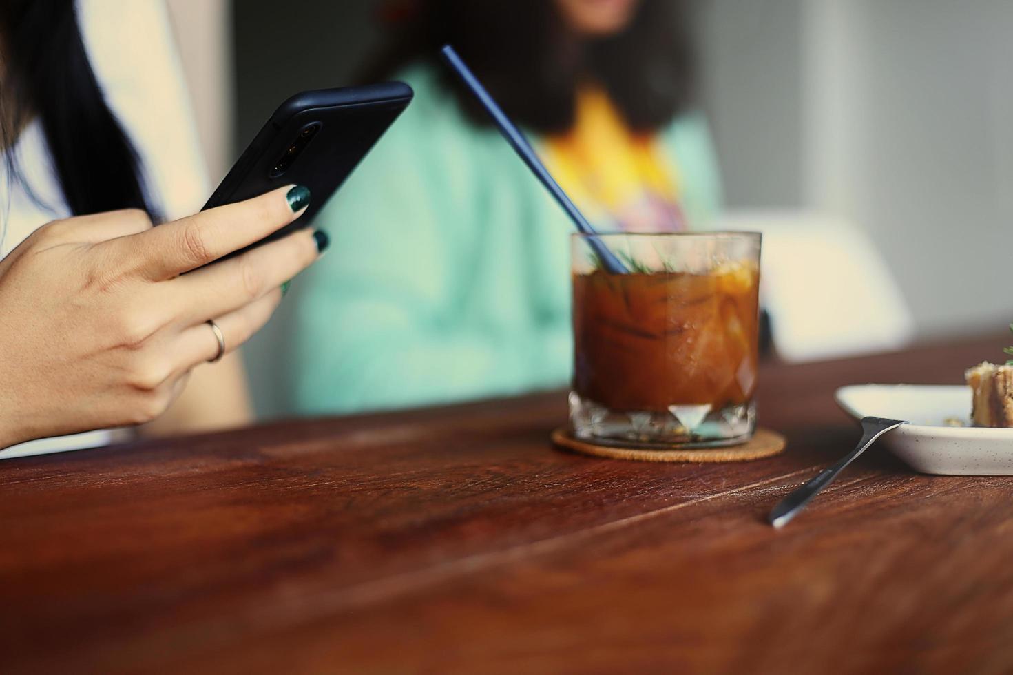 meisje maakt gebruik van mobiele telefoon tijdens koffiepauze foto