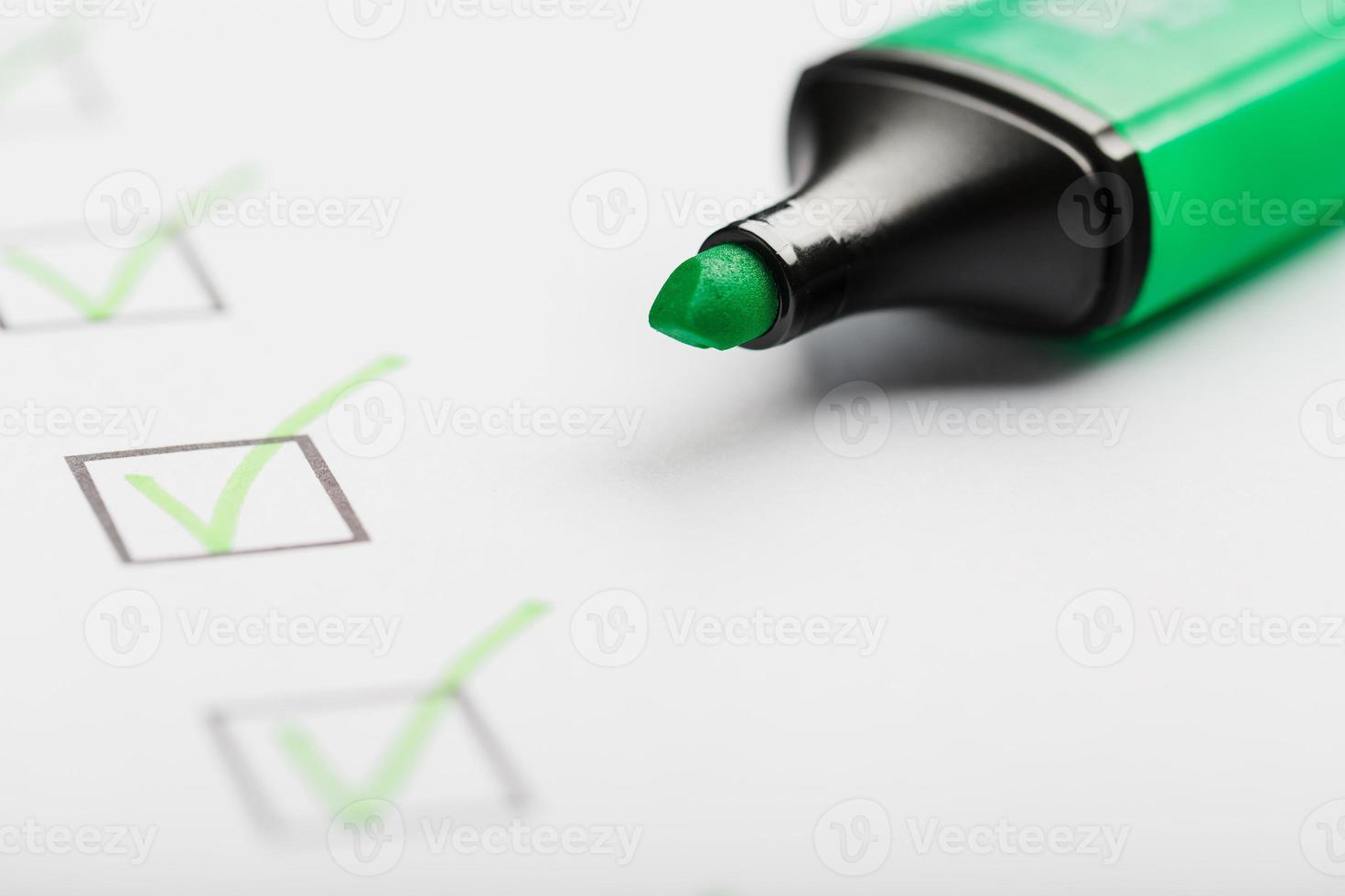 groen markeerstift met markeringen Aan de checklist vel. foto