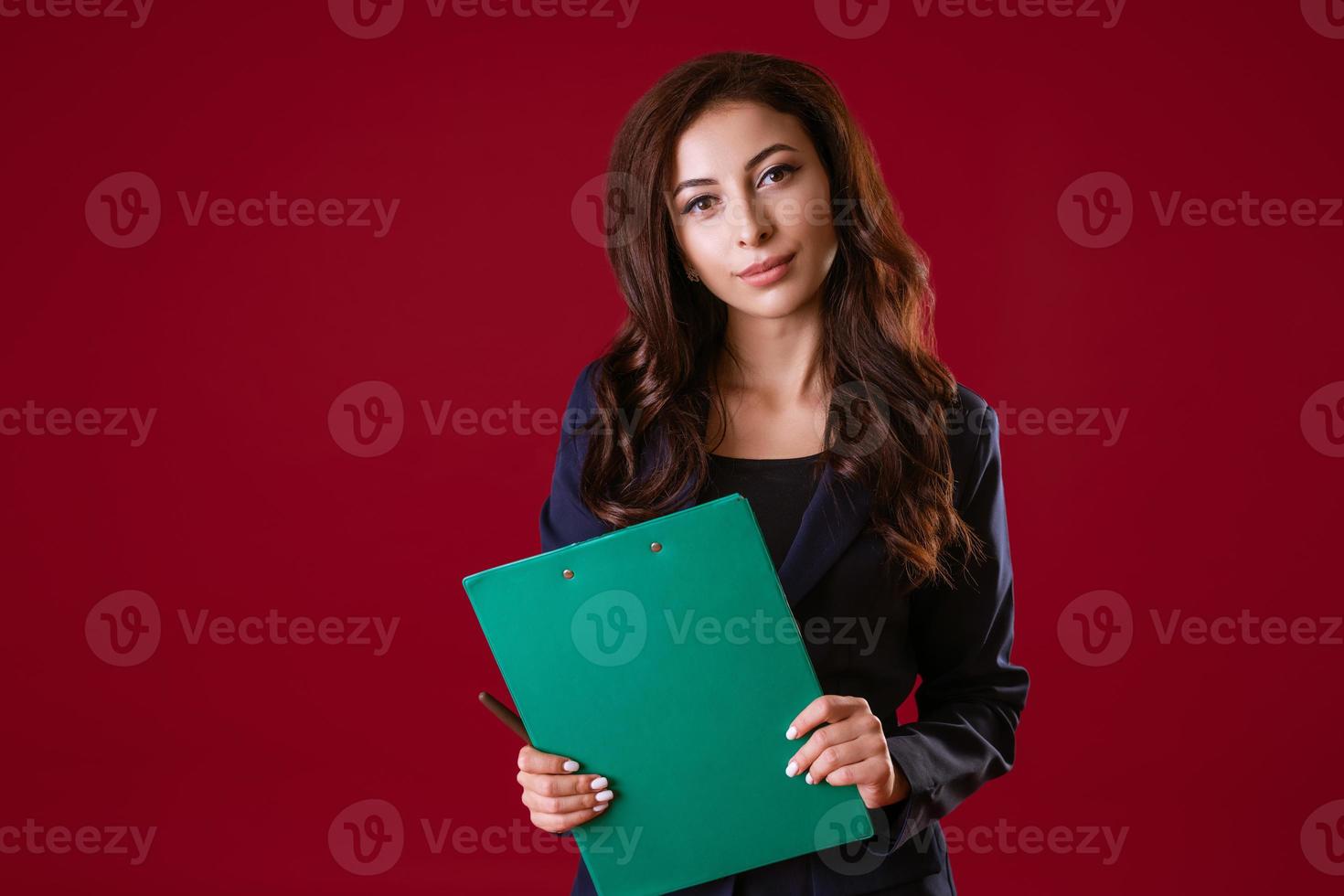 een vrouw regisseur is Holding documenten en glimlachen Aan een rood achtergrond. foto