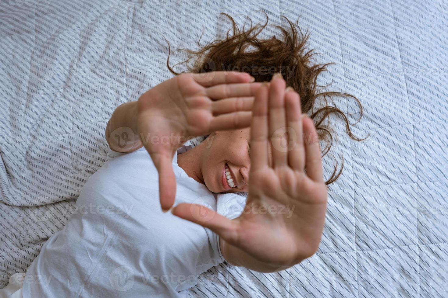 dolblij vrouw in pyjama uitrekken uit haar armen foto