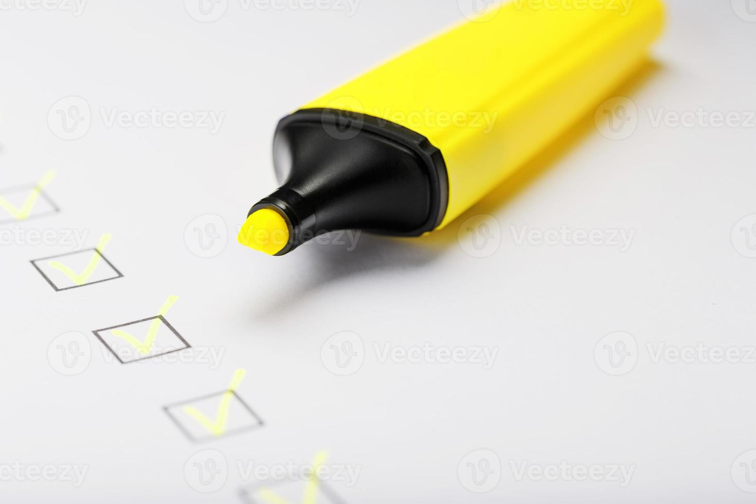 geel markeerstift met markeringen Aan de checklist vel. foto