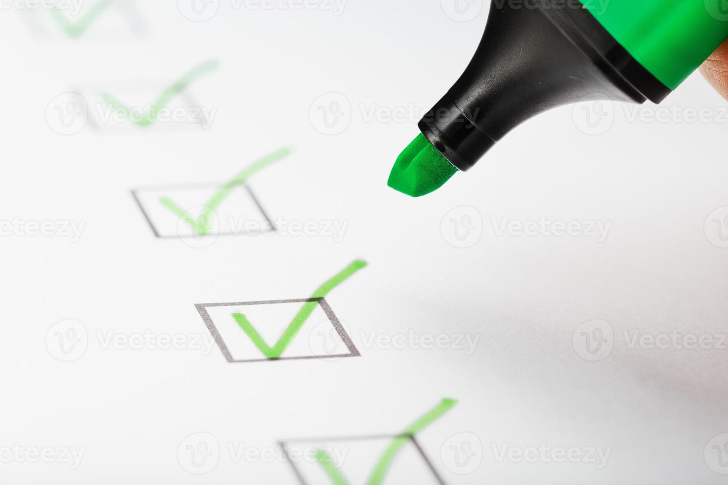 groen markeerstift met markeringen Aan de checklist vel. foto