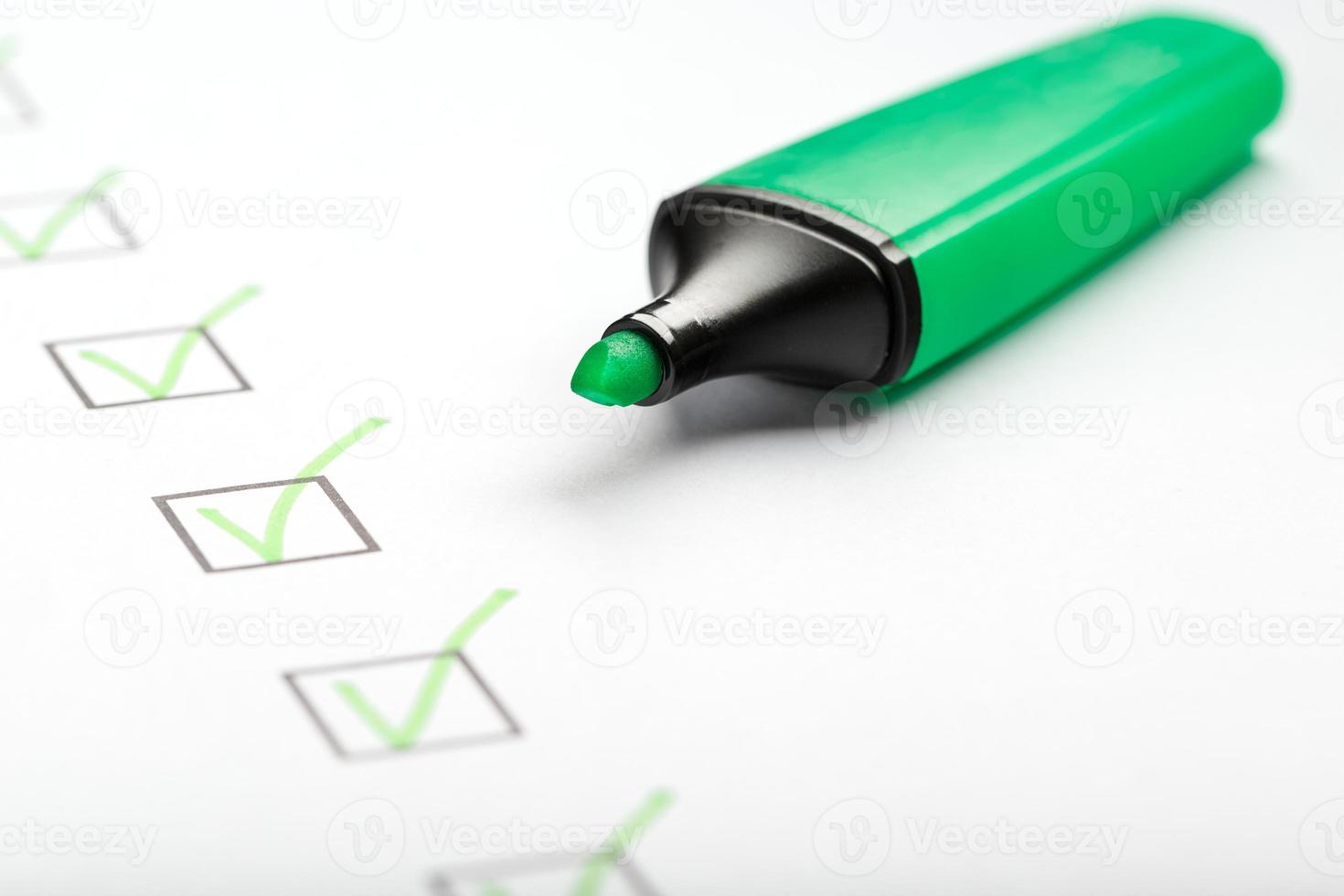 groen markeerstift met markeringen Aan de checklist vel. foto