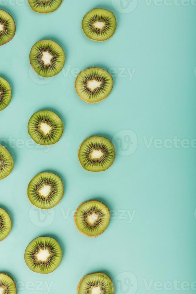 de patronen van de plakjes van kiwi fruit Aan groen achtergrond net zo een doorlopend achtergrond. foto