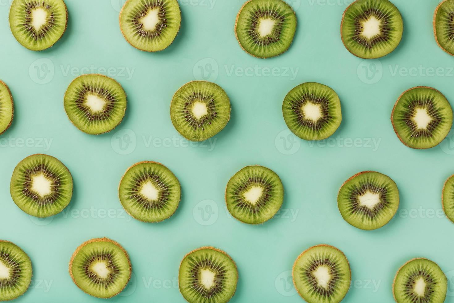 de patronen van de plakjes van kiwi fruit Aan groen achtergrond net zo een doorlopend achtergrond. foto