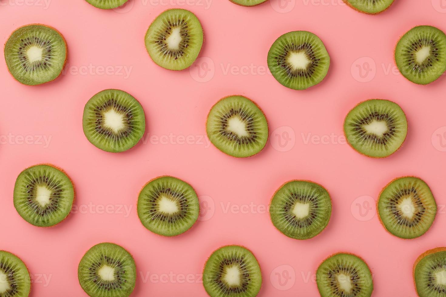 rijp kiwi plakjes in patronen Aan een roze achtergrond. foto