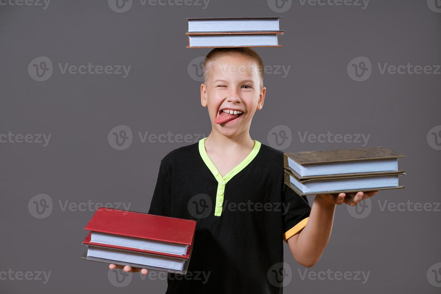 grappig jongen Holding een boek in zijn handen en Aan zijn hoofd foto