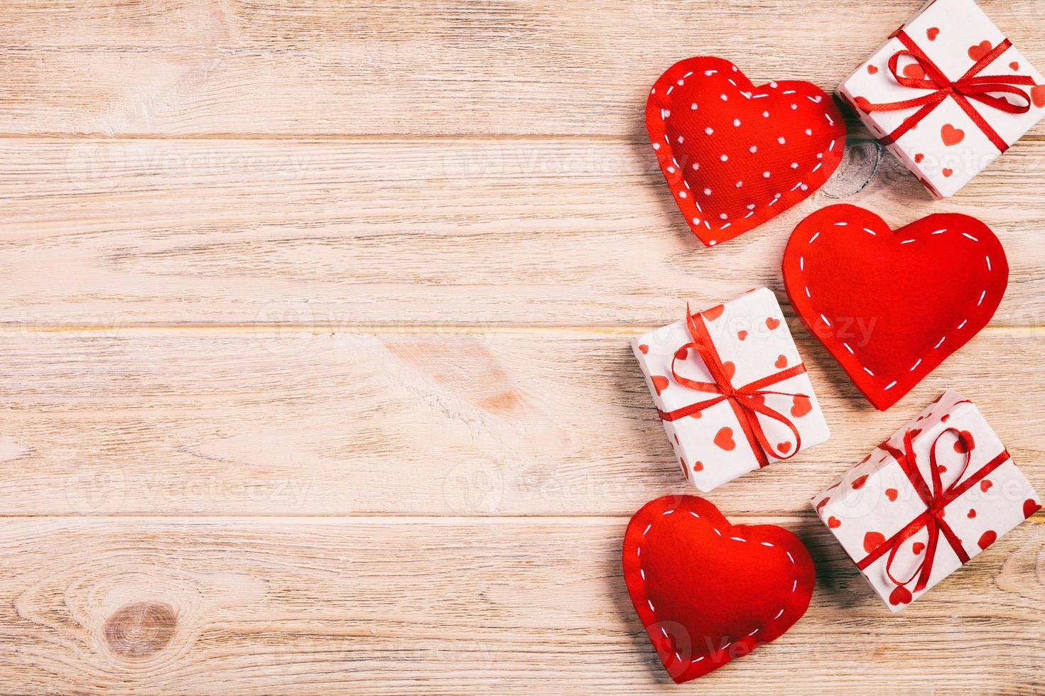 Valentijn of andere vakantie handgemaakt Cadeau in papier met rood harten en cadeaus doos in vakantie wikkel. Cadeau doos van geschenk Aan oranje houten tafel top visie met kopiëren ruimte, leeg ruimte voor ontwerp foto