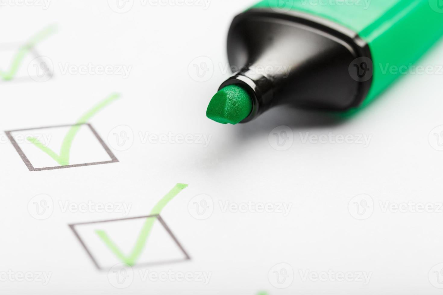 groen markeerstift met markeringen Aan de checklist vel. foto