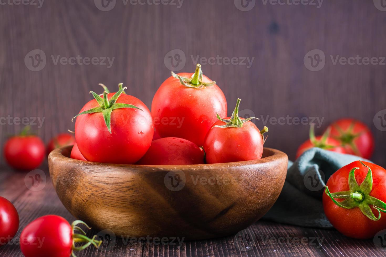 biologisch rijp tomaten in een kom Aan een houten tafel. oogst en lokaal producten. foto