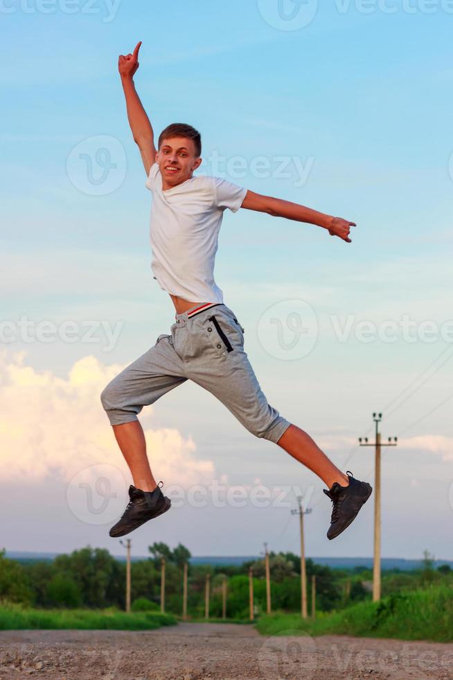 gelukkig jong Mens jumping in omhoog Aan natuur foto