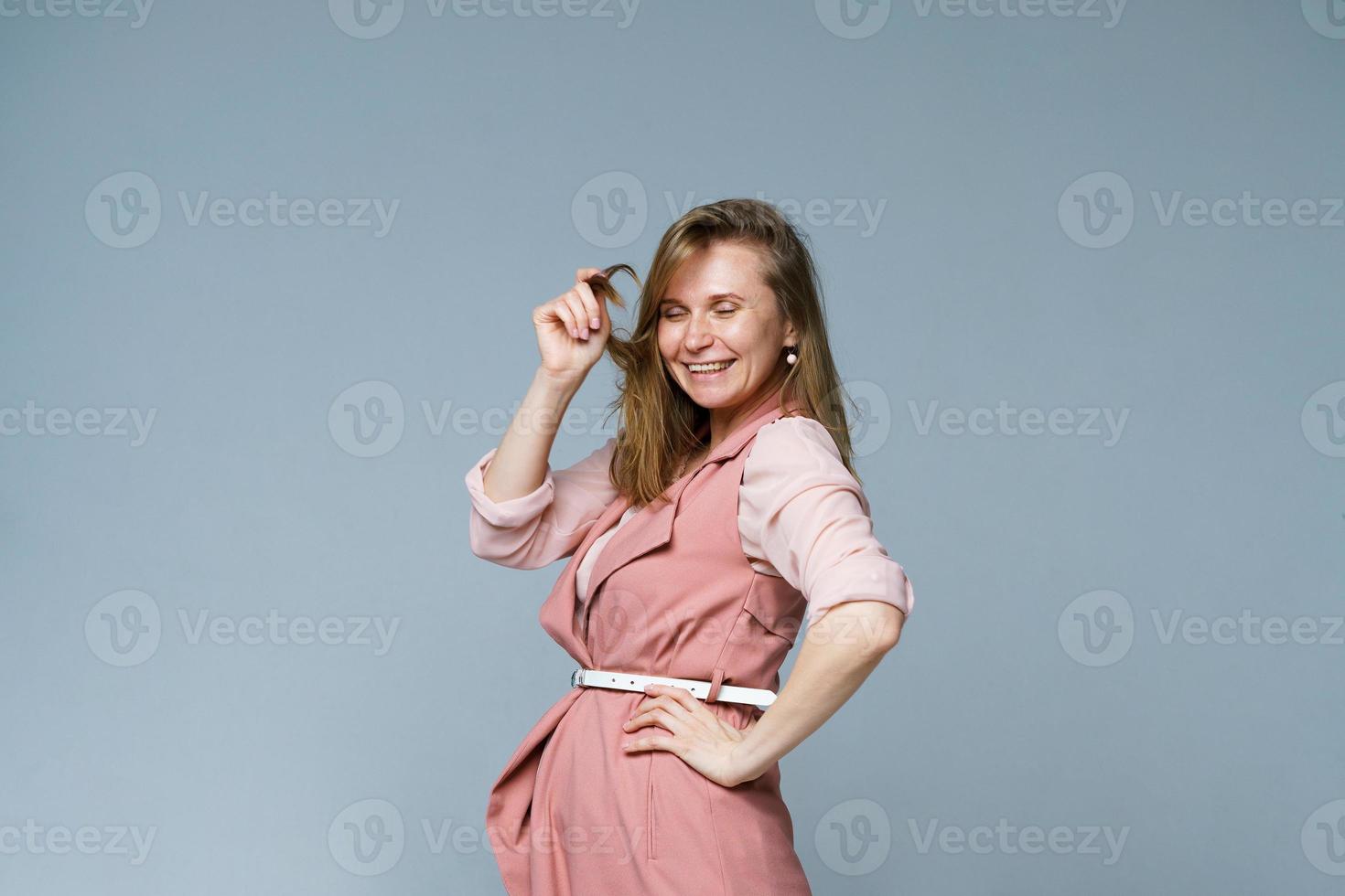 positief emoties. portret van een opgewonden Kaukasisch vrouw in roze kleren foto