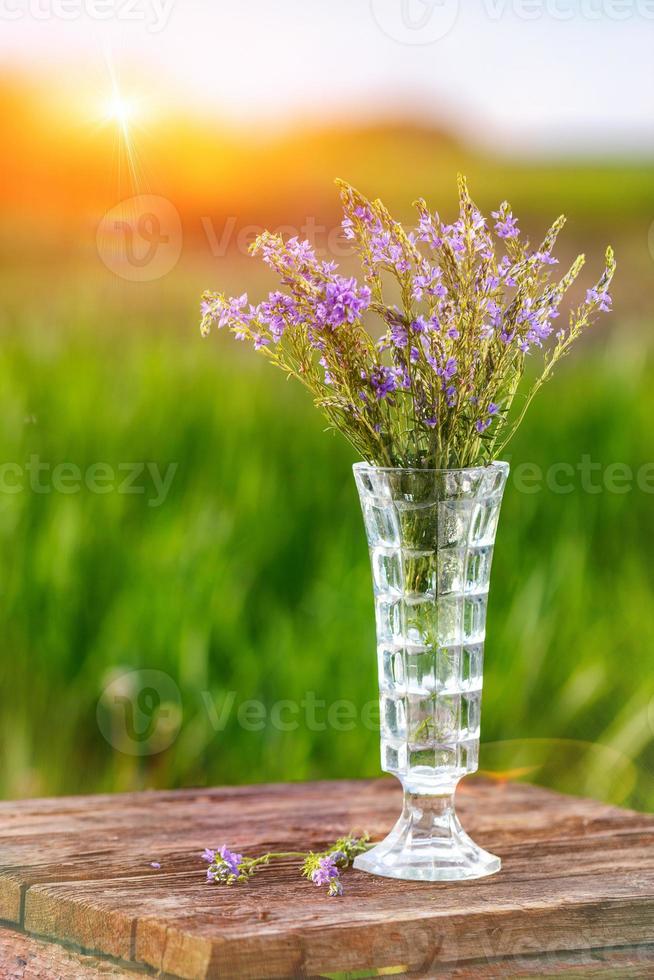 lila boeket in een vaas Aan een houten tafel foto