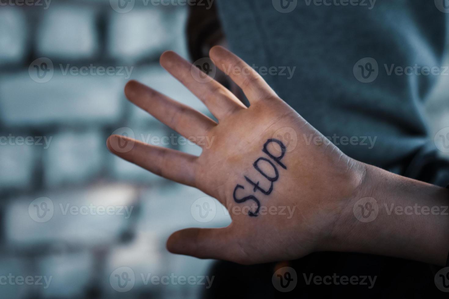 de jongen sluit zijn hand, geschreven Aan zijn hand- hou op, wreedheid naar kinderen foto