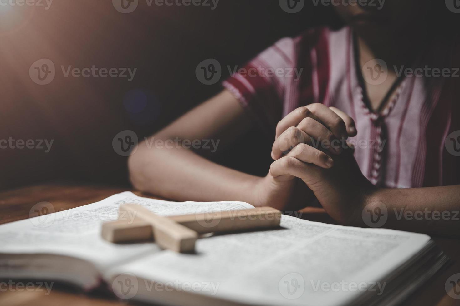 religieus christen jongen bidden over- Bijbel binnenshuis foto