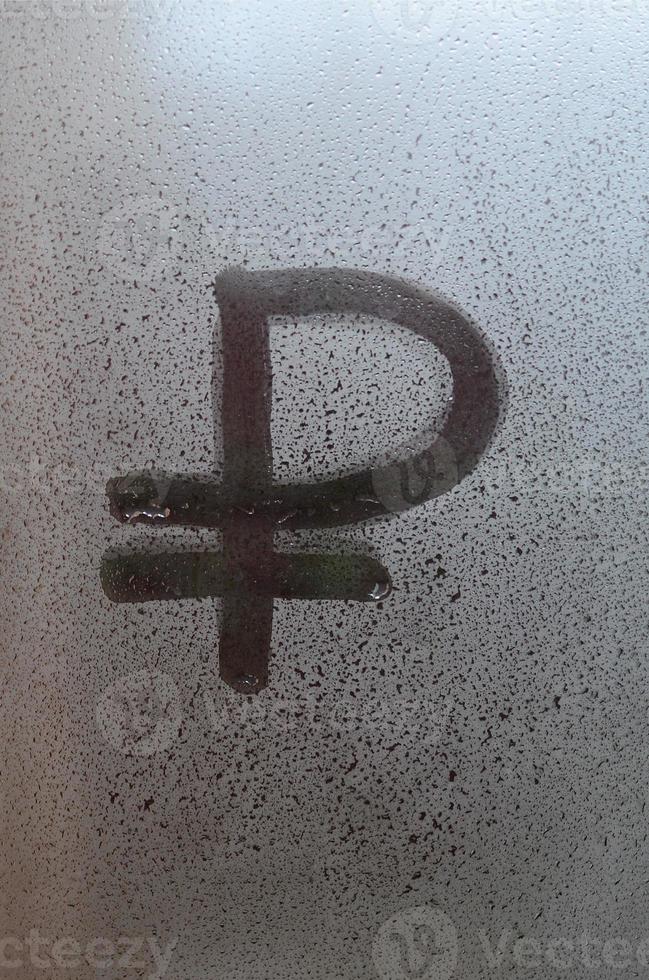 symbool van de Russisch roebel is geschreven met een vinger Aan de oppervlakte van de beneveld glas foto