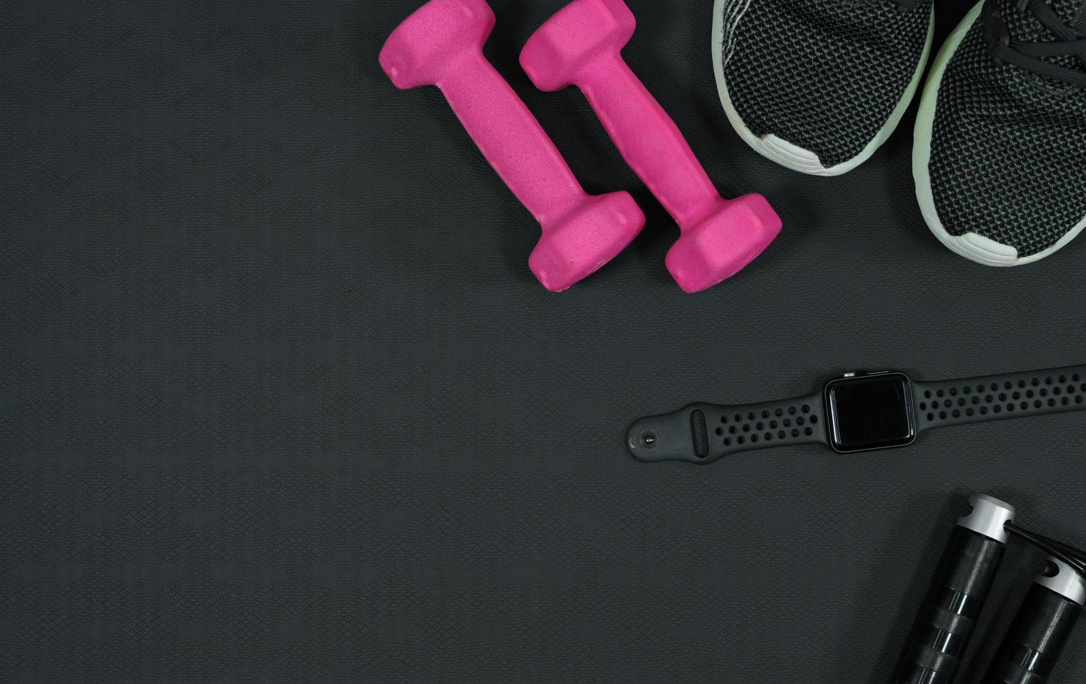 roze halter achtergrond en sport- schoenen slim kijk maar overslaan touw Aan zwart rubber achtergrond.fitness uitrusting achtergrond concept foto