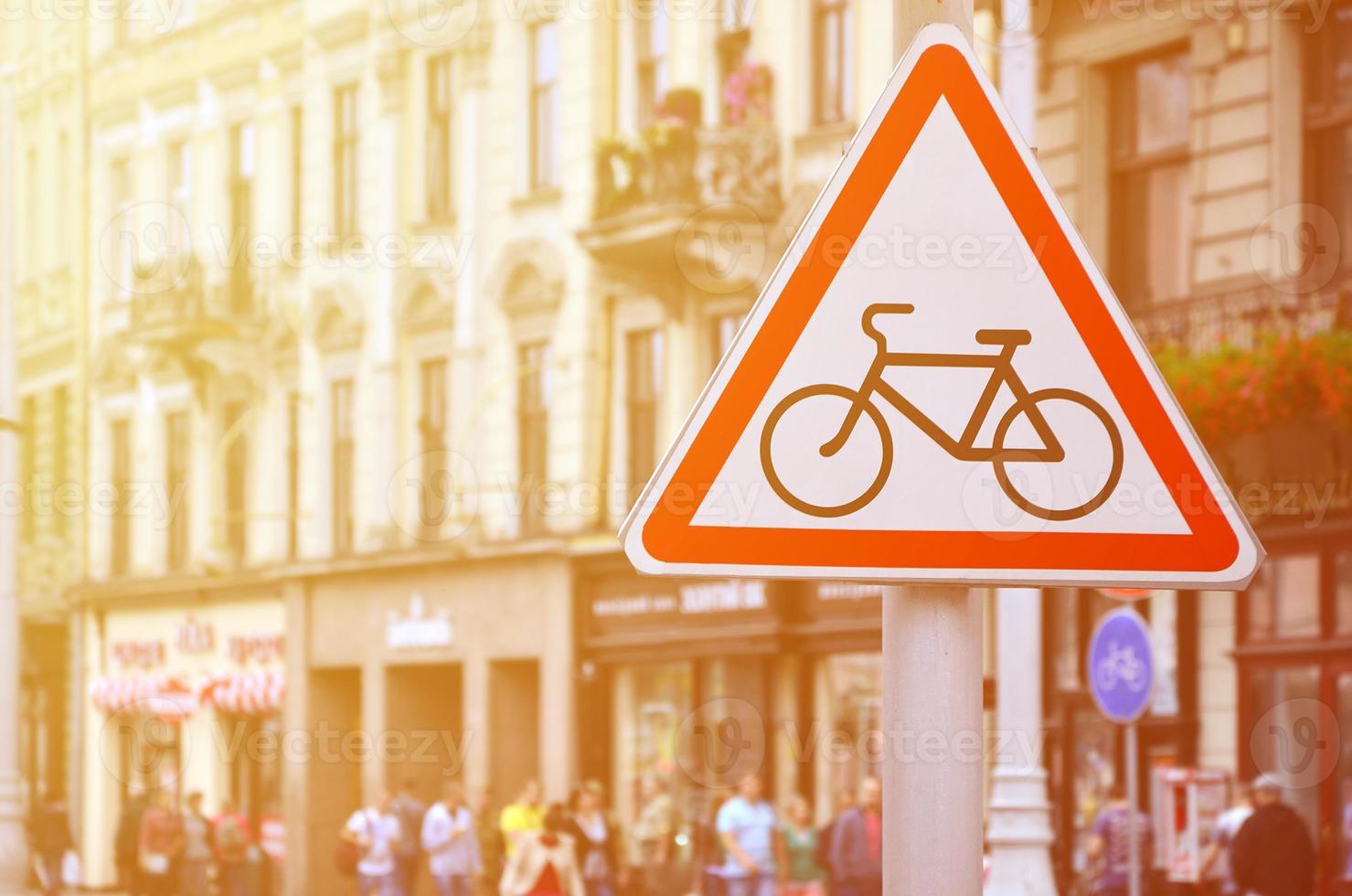 een weg teken met een afbeelding van een fiets tegen een druk straat. wielersport toegestaan foto
