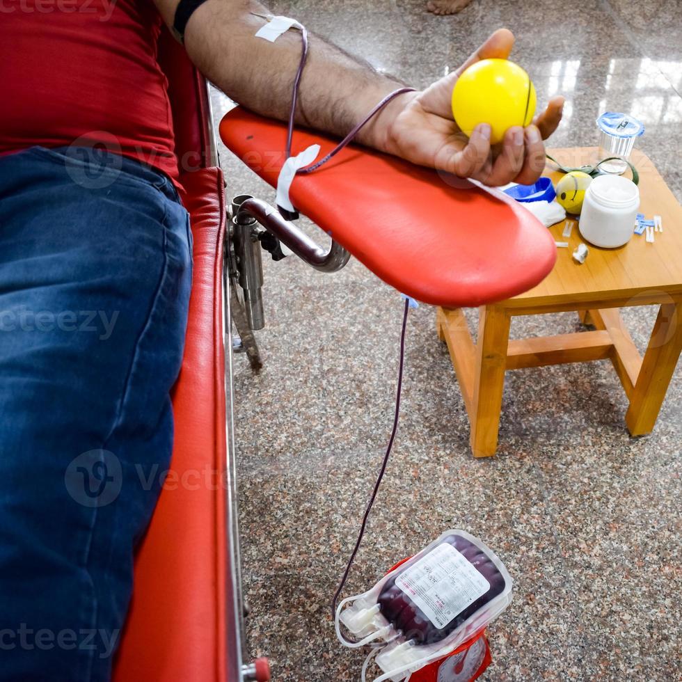 bloeddonor in bloeddonatiekamp gehouden met een springkussen in de hand in balaji-tempel, vivek vihar, delhi, india, afbeelding voor wereldbloeddonordag op 14 juni elk jaar, bloeddonatiekamp foto