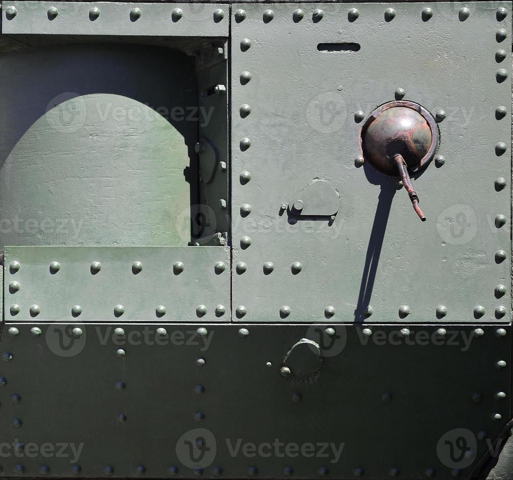 de structuur van de muur van de tank, gemaakt van metaal en versterkt met een menigte van bouten en klinknagels. afbeeldingen van de aan het bedekken van een gevecht voertuig van de tweede wereld oorlog met een begeleid machine geweer foto