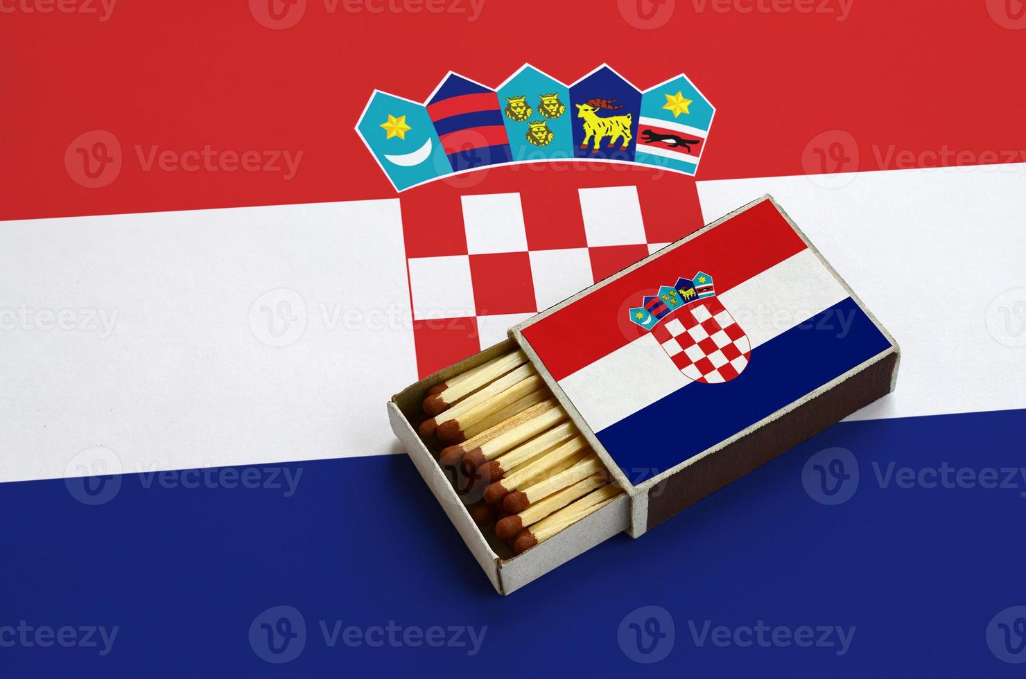 Kroatië vlag is getoond in een Open luciferdoosje, welke is gevulde met wedstrijden en leugens Aan een groot vlag foto