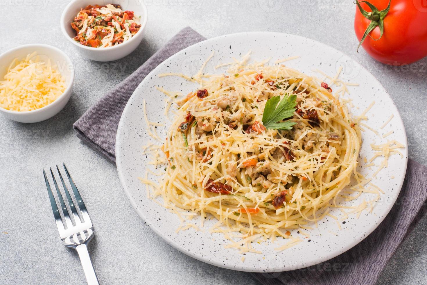 spaghetti pasta bolognese met groente saus en kaas. deel Aan een bord. licht beton achtergrond. foto