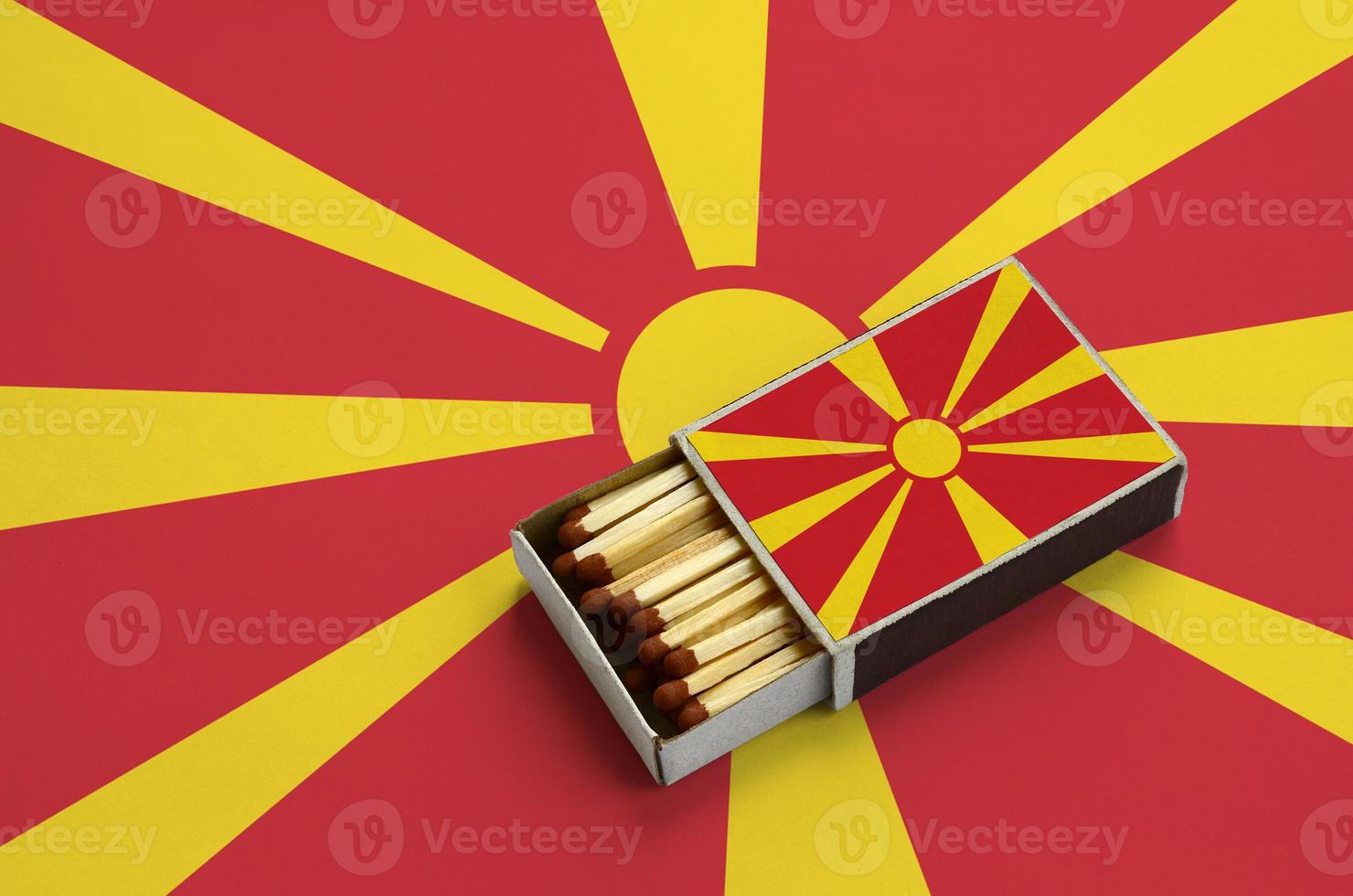 Macedonië vlag is getoond in een Open luciferdoosje, welke is gevulde met wedstrijden en leugens Aan een groot vlag foto