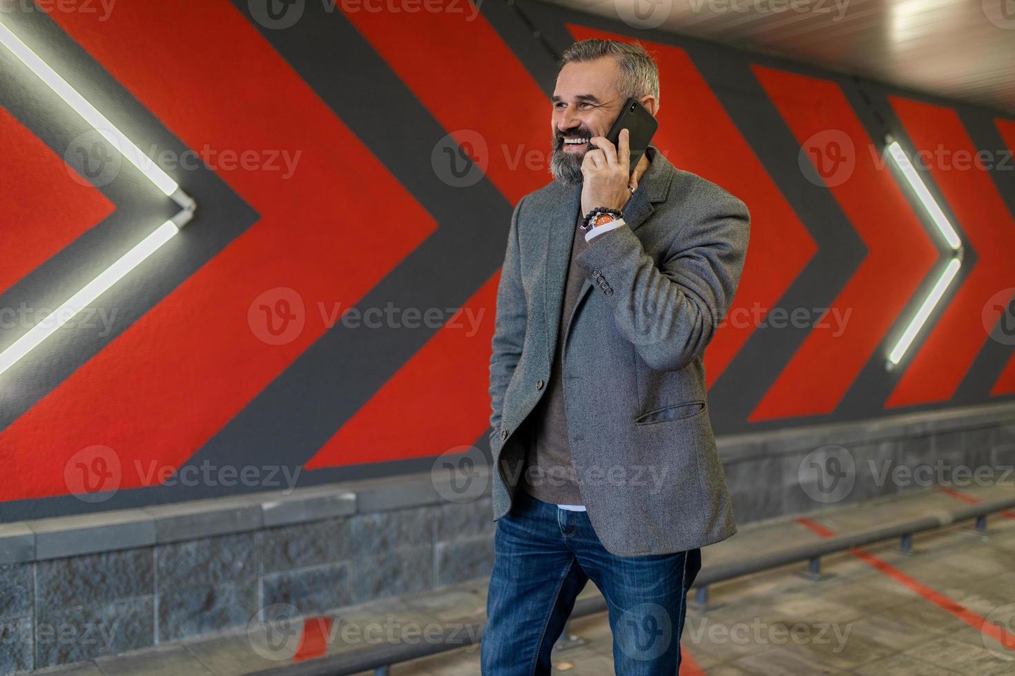 portret van een echt ambitieus geslaagd volwassen mannetje zakenman met een mobiel telefoon tegen de achtergrond van rood pijlen foto