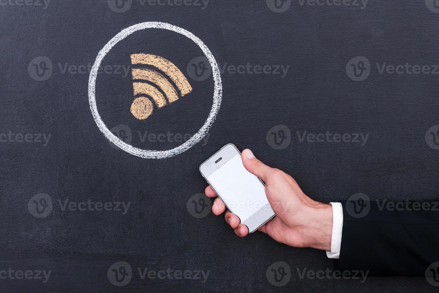 Verbinden de internetten. concept van menselijk hand- Holding telefoon tegen sharing symbool krijt tekening Aan schoolbord foto