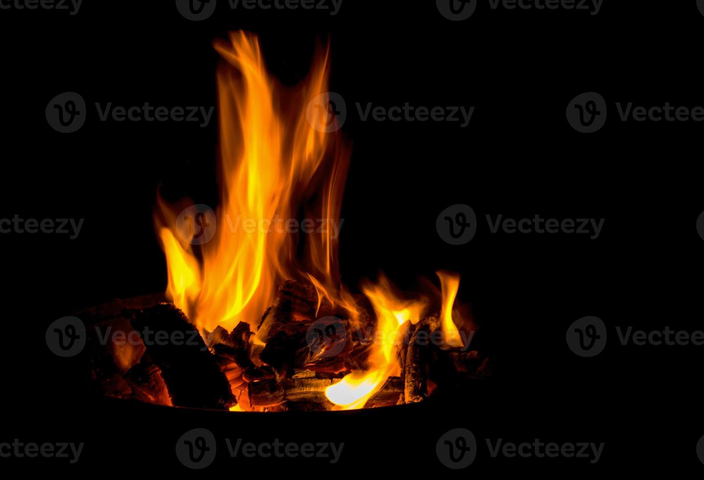 een vlam brandend in een koperslager in de donker foto