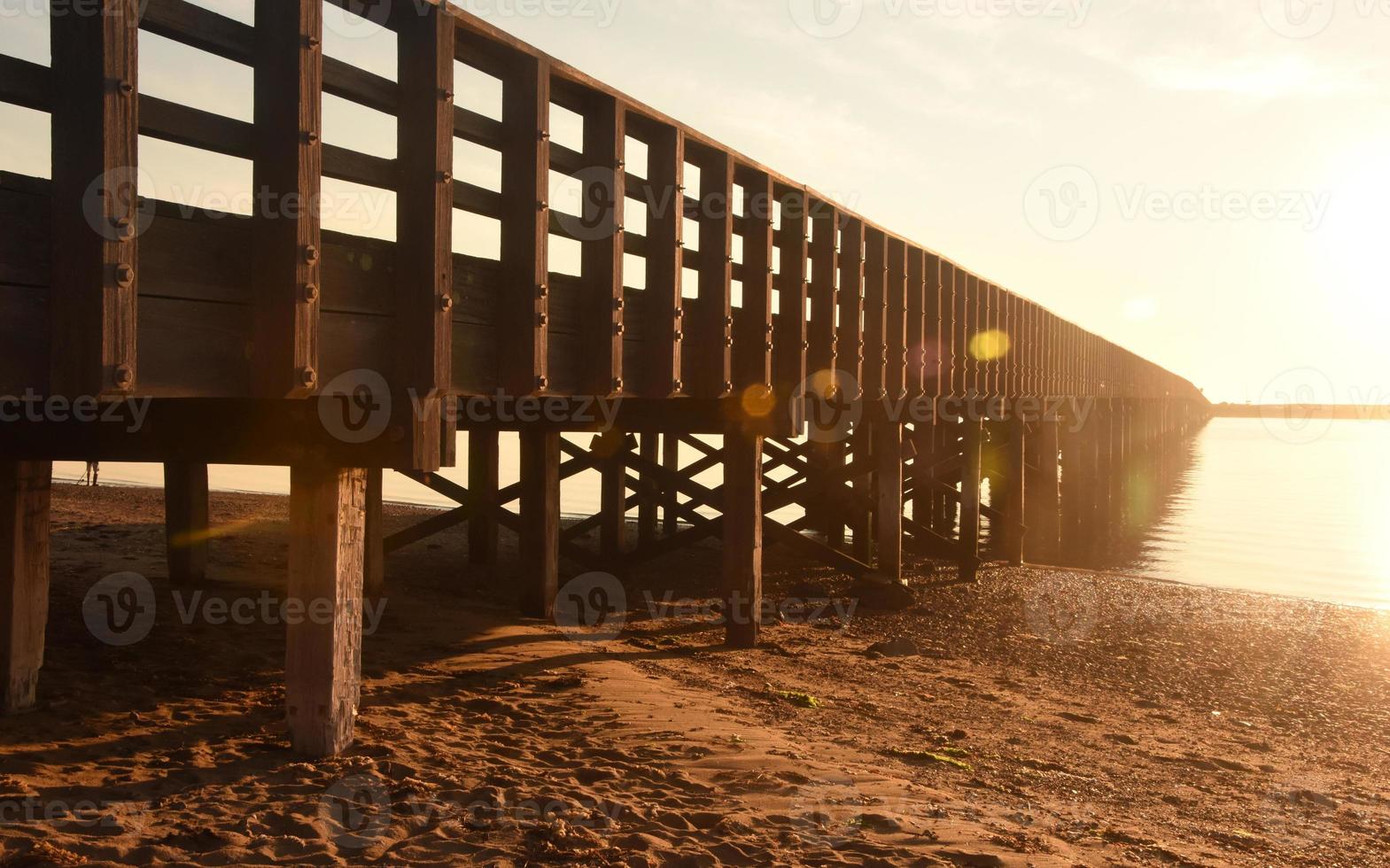 zon glinsterend uit duxbury baai met een brug foto