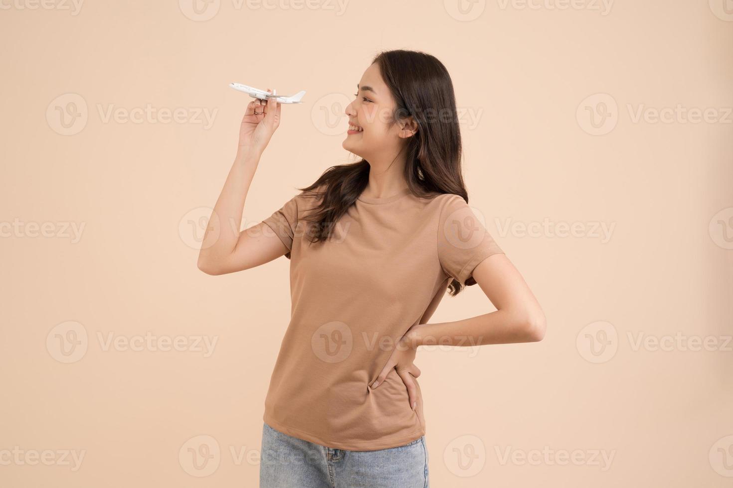 gelukkig jong vrouw staand en Holding een wit speelgoed- vlak dromer in de studio foto