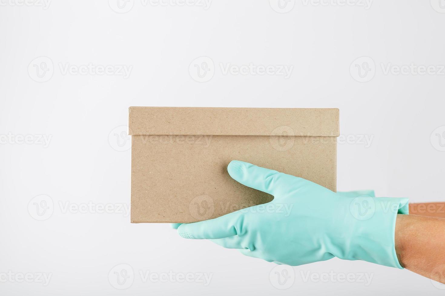 Bezig met verzenden karton dozen in de handen van een koerier in rubber handschoenen. foto