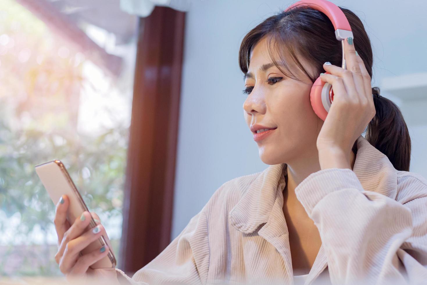 Aziatische vrouw luisteren naar muziek foto