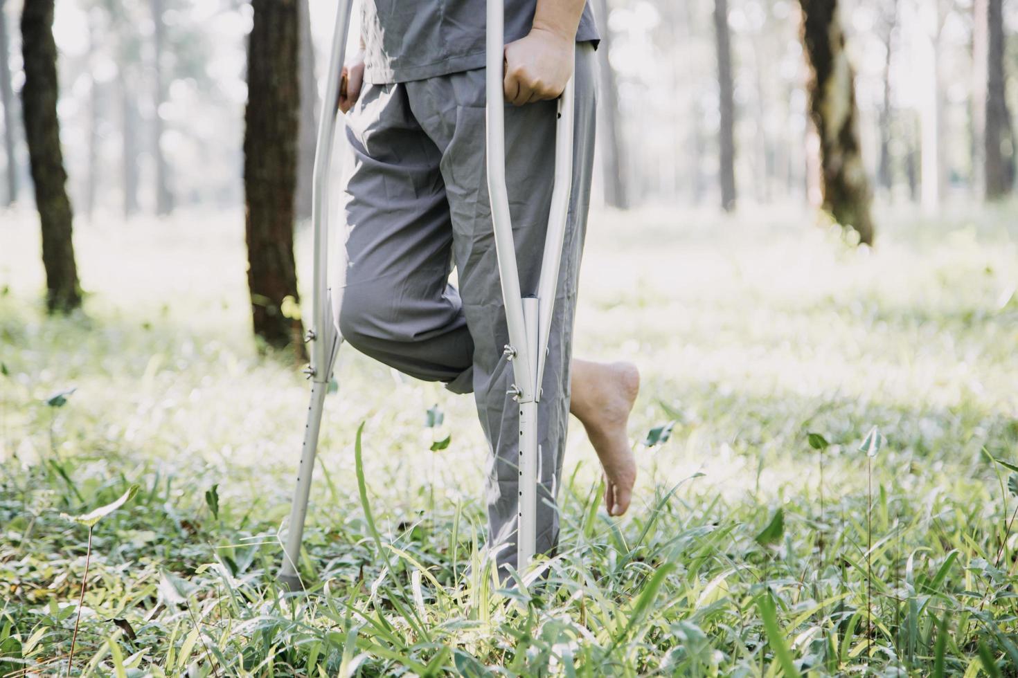 jong Aziatisch fysiek therapeut werken met senior vrouw Aan wandelen met een wandelaar foto